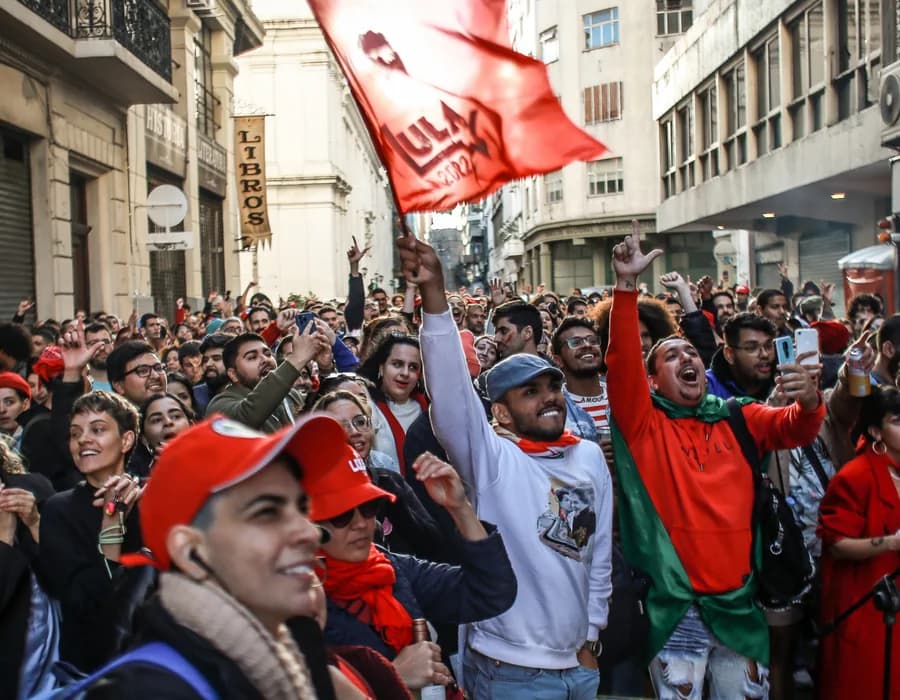 Multidão em ato de rua com bandeira vermelha